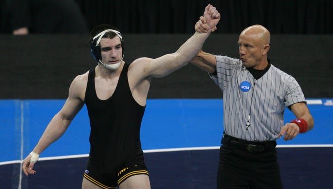 Iowa's Brent Metcalf has his hand raised in victory after beating Ohio State's Lance Palmer in the 149-pound championship match during the 2010 NCAA Wrestling Championships in Omaha.