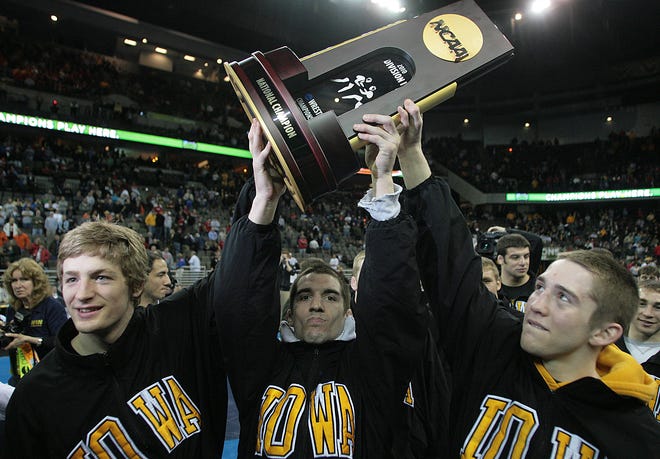 From left, Jay Borschel, Brent Metcalf and Matt McDonough hold up the team trophy after Iowa secured the 2010 NCAA Wrestling Championship, Saturday, March 20, 2010, at the Qwest Center Omaha. Each of those three claimed individual national championships for the Hawkeyes.
