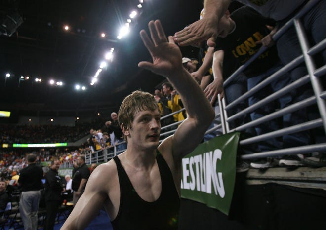 Iowa's Jay Borschel high fives Hawkeyes fans after defeating Cornell's Mack Lewnes in the 174-pound championship match during the 2010 NCAA Wrestling Championships in Omaha. A short time later, Borschel and the Hawkeyes were also celebrating a team championship.