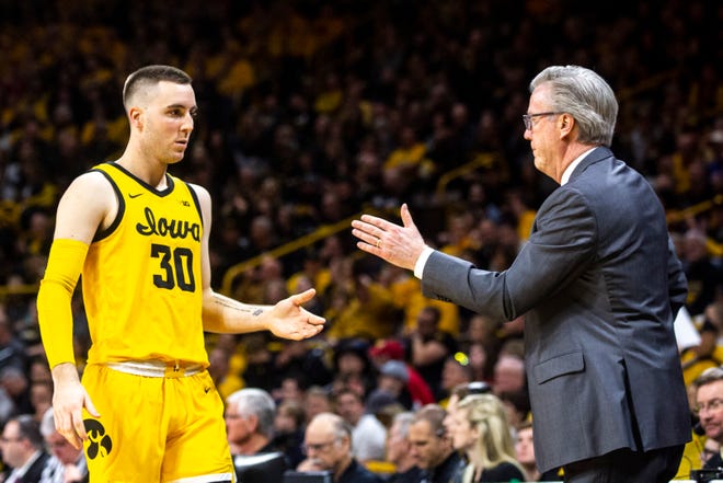 Iowa forward Connor McCaffery (30) gets a high-five from head coach Fran McCaffery while heading to the bench during a NCAA Big Ten Conference men's basketball game, Saturday, Feb. 8, 2020, at Carver-Hawkeye Arena in Iowa City, Iowa.