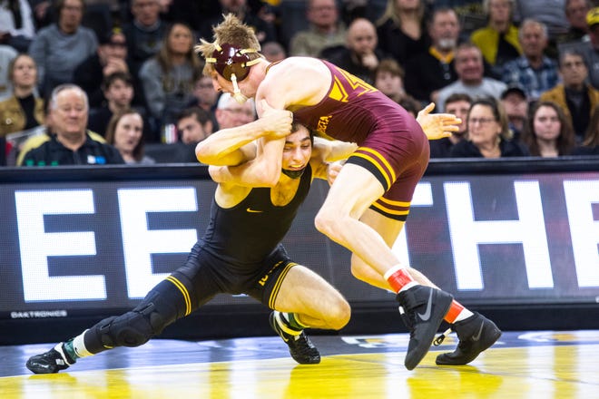 Iowa's Austin DeSanto, left, wrestles Minnesota's Boo Dryden at 133 pounds during a NCAA Big Ten Conference wrestling dual, Saturday, Feb. 15, 2020, at Carver-Hawkeye Arena in Iowa City, Iowa.