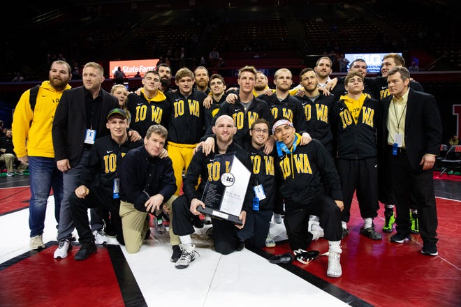 The Iowa wrestling team surrounds the trophy after winning the Big 10 Wrestling Championships March 8, 2020; Piscataway, NJ, USA.
