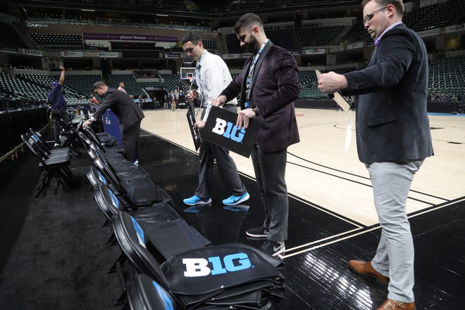 Staff members remove signage after the Michigan Wolverines vs. Rutgers Scarlet Knights first round Big Ten tournament game at Bankers Life Fieldhouse in Indianapolis, Indiana was canceled due to the Coronavirus Pandemic Thursday, March 12, 2020.