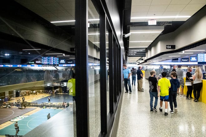 People walk on the concourse overlooking the GreenState Family Fieldhouse as wrestlers warm up during the opening session of the USA Wrestling Senior National Championships, Friday, Oct. 9, 2020, at the Xtream Arena in Coralville, Iowa.