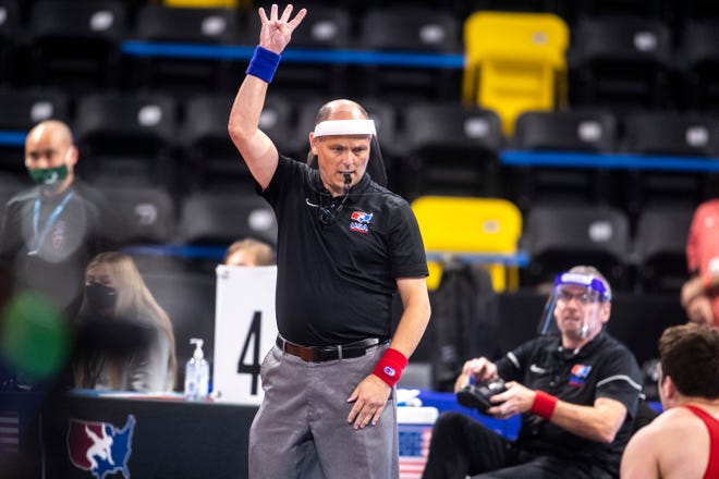 An official wearing a face mask signals during the USA Wrestling Senior National Championships, Friday, Oct. 9, 2020, at the Xtream Arena in Coralville, Iowa.