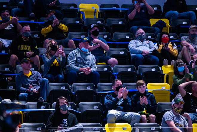Fans wearing face masks sit apart from each other during the USA Wrestling Senior National Championships, Sunday, Oct. 11, 2020, at the Xtream Arena in Coralville, Iowa.
