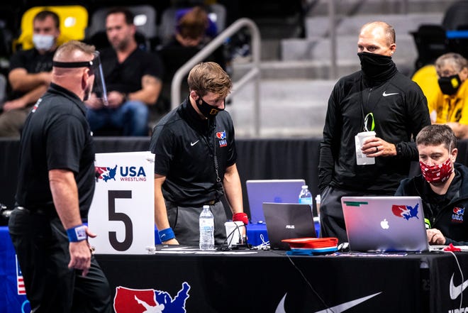 Officials wearing face masks and shields review a challenge during the USA Wrestling Senior National Championships, Friday, Oct. 9, 2020, at the Xtream Arena in Coralville, Iowa.