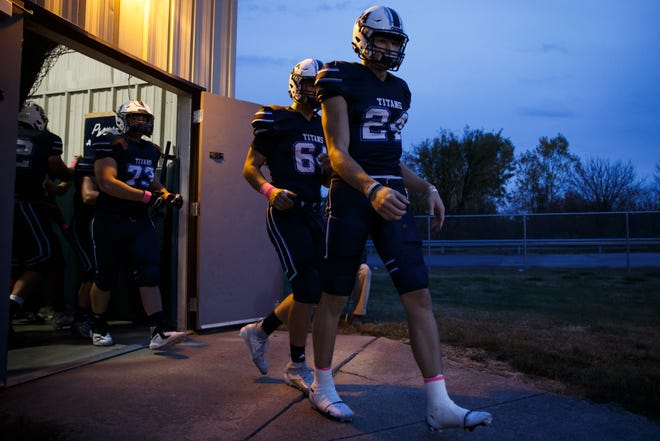 Lewis Central's Thomas Fidone leads the Titans onto the field before their football game against Creston on Friday, Oct. 16, 2020, in Council Bluffs.