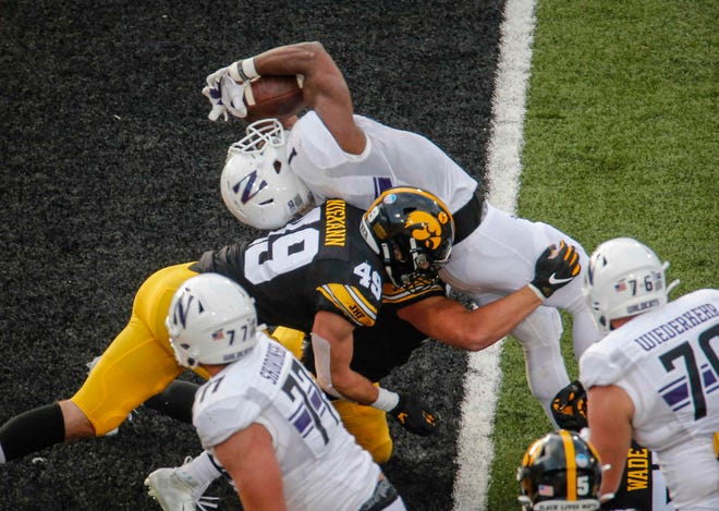 Northwestern senior running back Jesse Brown bends backward over the goal line for a touchdown against Iowa at Kinnick Stadium in Iowa City on Saturday, Oct. 31, 2020.