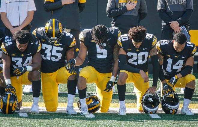Members of the Iowa Hawkeyes football team take a knee during the National Anthem prior to kickoff against Northwestern at Kinnick Stadium in Iowa City on Saturday, Oct. 31, 2020.