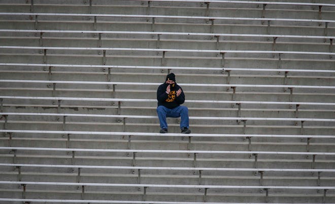 An Iowa fan applauds a first down while observing social distance requirements at Kinnick Stadium in Iowa City on Saturday, Oct. 31, 2020.
