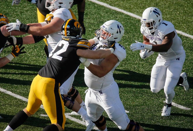 Iowa sophomore defensive lineman John Waggoner flattens a Northwestern lineman as he makes a play for a tackle at Kinnick Stadium in Iowa City on Saturday, Oct. 31, 2020.