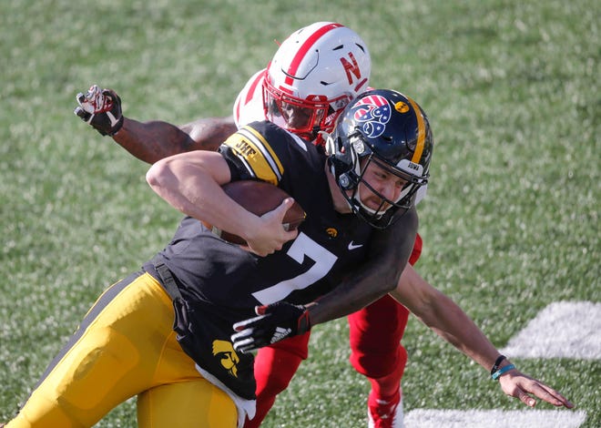 Iowa sophomore quarterback Spencer Petras is hit by a Nebraska defender after scrambling with the ball for a gain of yards in the first quarter at Kinnick Stadium in Iowa City on Friday, Nov. 27, 2020.
