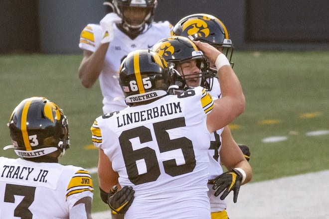 Dec 5, 2020; Champaign, Illinois, USA; Iowa Hawkeyes offensive lineman Tyler Linderbaum (65) hugs tight end Sam LaPorta (84) after scoring a touchdown during the first half against the Illinois Fighting Illini at Memorial Stadium. Mandatory Credit: Patrick Gorski-USA TODAY Sports