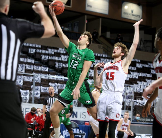 SIOUX FALLS, SD - DECEMBER 10: Filip Rebraca #12 of the North Dakota Fighting Hawks drives to the basket and draws a foul on Brady Heiman #45 of the South Dakota Coyotes during the CU Mortgage Direct Dakota Showcase at the Sanford Pentagon on December 10, 2020 in Sioux Falls, South Dakota. (Photo by Dave Eggen/Inertia)