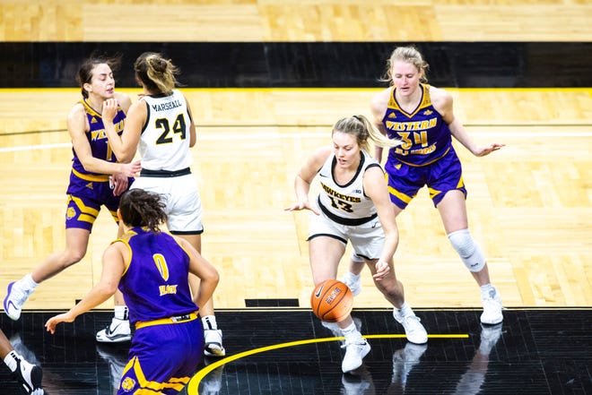 Iowa forward Shateah Wetering (13) dribbles past Western Illinois guard Sam Pryor (34) during a NCAA non-conference women's basketball game, Tuesday, Dec. 22, 2020, at Carver-Hawkeye Arena in Iowa City, Iowa.