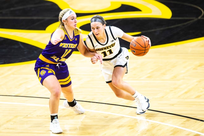 Iowa guard Megan Meyer, right, drives to the basket as Western Illinois guard Mallory McDermott defends during a NCAA non-conference women's basketball game, Tuesday, Dec. 22, 2020, at Carver-Hawkeye Arena in Iowa City, Iowa.
