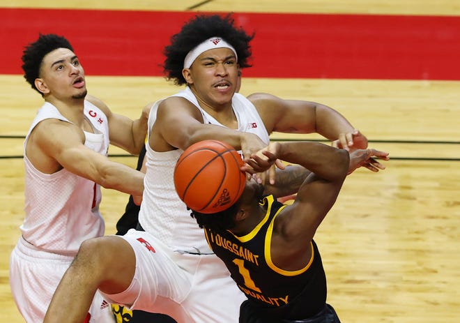 PISCATAWAY, NJ - JANUARY 02: Ron Harper Jr. #24 of the Rutgers Scarlet Knights blocks a shot Joe Toussaint (1) of the Iowa Hawkeyes as Rutgers' Geo Baker #0 helps out during the first half of a college basketball game at Rutgers Athletic Center on January 2, 2021 in Piscataway, New Jersey.