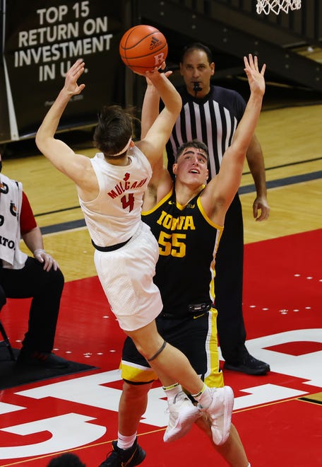 PISCATAWAY, NJ - JANUARY 02: Paul Mulcahy #4 of the Rutgers Scarlet Knights attempts a shot as Luka Garza #55 of the Iowa Hawkeyes defends during the first half of a college basketball game at Rutgers Athletic Center on January 2, 2021 in Piscataway, New Jersey. Iowa defeated Rutgers 77-75.