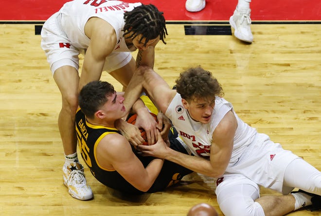 PISCATAWAY, NJ - JANUARY 02: Caleb McConnell #22 and Dean Reiber #21 of the Rutgers Scarlet Knights fights Luka Garza #55 of the Iowa Hawkeyes for a loose ball during the first half of a college basketball game at Rutgers Athletic Center on January 2, 2021 in Piscataway, New Jersey. Iowa defeated Rutgers 77-75.