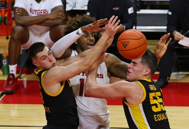 PISCATAWAY, NJ - JANUARY 02: Myles Johnson #15 of the Rutgers Scarlet Knights fights off CJ Fredrick #5 and Luka Garza #55 of the Iowa Hawkeyes during the second half of a college basketball game at Rutgers Athletic Center on January 2, 2021 in Piscataway, New Jersey. Iowa defeated Rutgers 77-75.