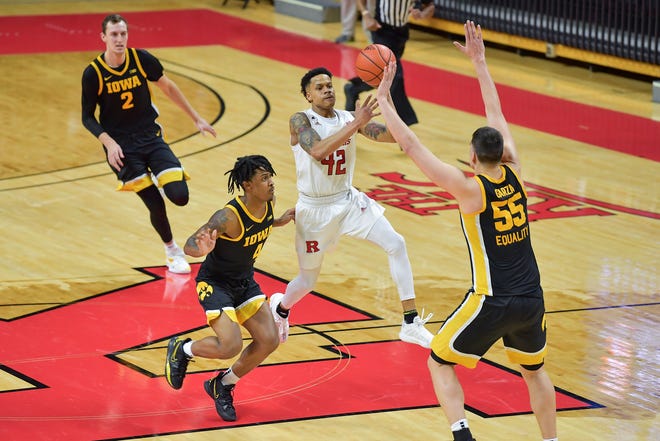 Jan 2, 2021; Piscataway, New Jersey, USA; Rutgers Scarlet Knights guard Jacob Young (42) shoots the ball as Iowa guard Ahron Ulis, left, and center Luka Garza (55) defend during the second half against the Iowa Hawkeyes at Rutgers Athletic Center (RAC). Mandatory Credit: Catalina Fragoso-USA TODAY Sports