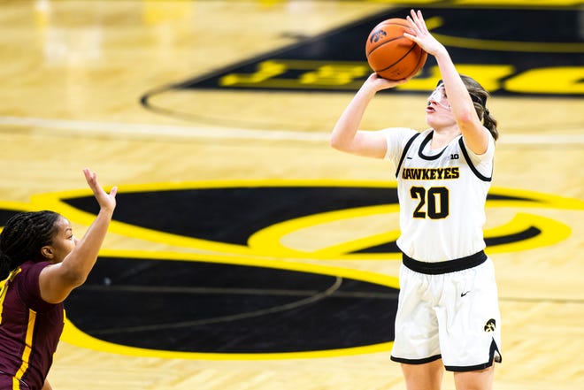 Iowa guard Kate Martin (20) makes a 3-point basket as Minnesota guard Gadiva Hubbard, left, defends during a NCAA Big Ten Conference women's basketball game, Wednesday, Jan. 6, 2021, at Carver-Hawkeye Arena in Iowa City, Iowa.