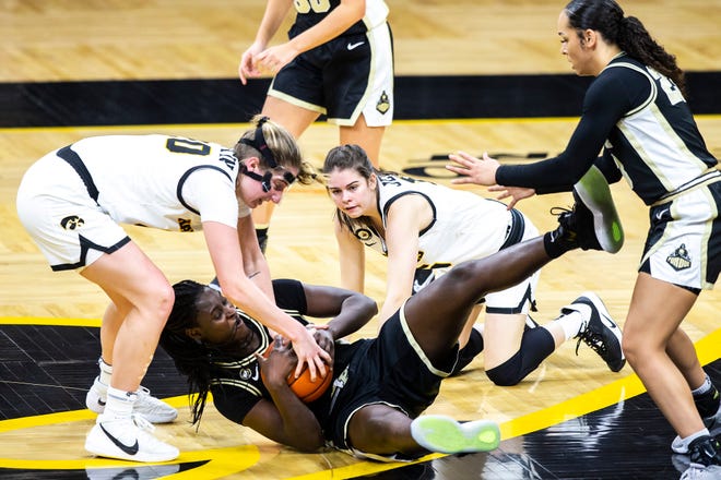 Iowa guard Kate Martin, left, and Iowa guard Lauren Jensen, second from right, dive for a jump ball against Purdue center Fatou Diagne, middle, as teammate Purdue guard Kayana Traylor, right, looks for a pass during a NCAA Big Ten Conference women's basketball game, Monday, Jan. 18, 2021, at Carver-Hawkeye Arena in Iowa City, Iowa.