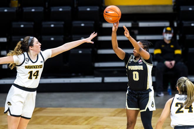 Purdue guard Brooke Moore (0) makes a basket as Iowa's McKenna Warnock (14) and Iowa guard Gabbie Marshall (24) defend during a NCAA Big Ten Conference women's basketball game, Monday, Jan. 18, 2021, at Carver-Hawkeye Arena in Iowa City, Iowa.