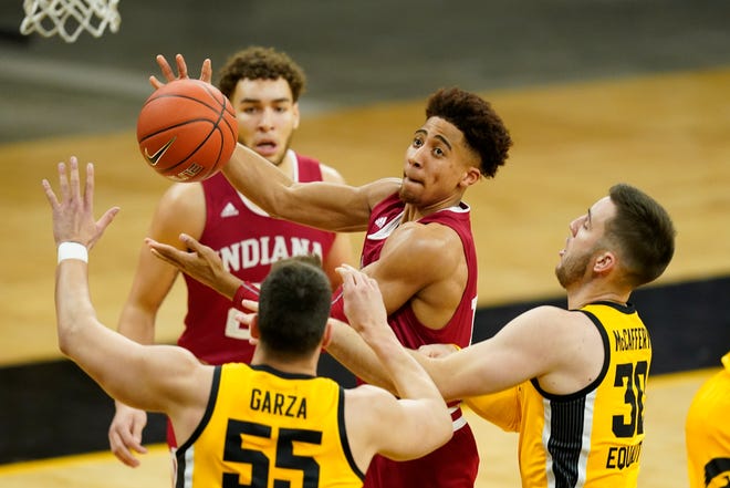 Indiana guard Rob Phinisee, center, drives to the basket over Iowa center Luka Garza (55) and guard Connor McCaffery, right, during the first half of an NCAA college basketball game, Thursday, Jan. 21, 2021, at Carver-Hawkeye Arena in Iowa City.