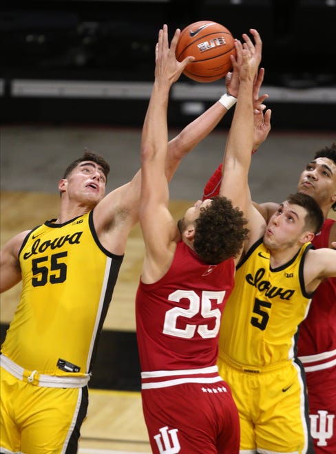 Forward Luka Garza #55  and guard C.J. Fredrick #5 of the Iowa Hawkeyes battle for a rebound against forward Race Thompson #25 of the Indiana Hoosiers on January 21, 2021, at Carver-Hawkeye Arena in Iowa City.