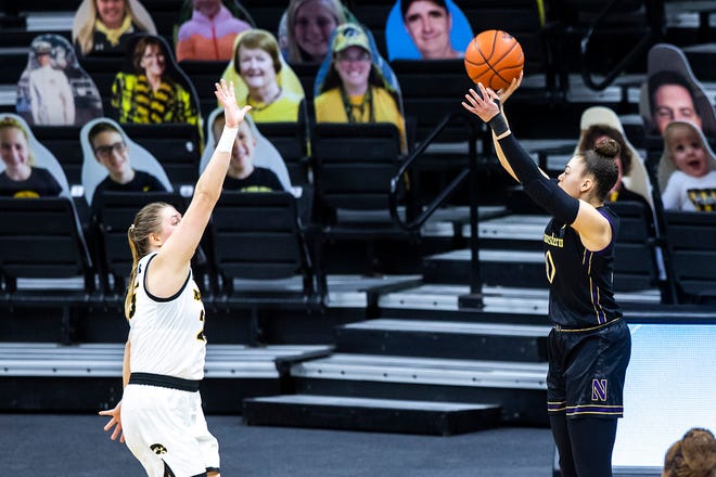 Northwestern guard Lindsey Pulliam, right, makes a 3-point basket as Iowa center Monika Czinano defends during the second half of a NCAA Big Ten Conference women's basketball game, Thursday, Jan. 28, 2021, at Carver-Hawkeye Arena in Iowa City, Iowa.