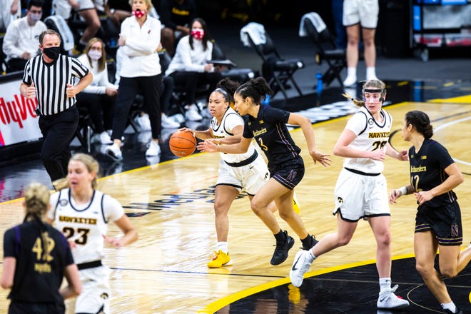 Iowa guard Alexis Sevillian, left, takes the ball up court as Northwestern's Sydney Wood (3) defends during the first half of a NCAA Big Ten Conference women's basketball game, Thursday, Jan. 28, 2021, at Carver-Hawkeye Arena in Iowa City, Iowa.