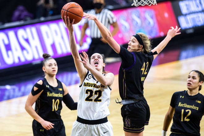 Iowa guard Caitlin Clark (22) makes a basket as Northwestern forward Anna Morris (42) defends during the first half of a NCAA Big Ten Conference women's basketball game, Thursday, Jan. 28, 2021, at Carver-Hawkeye Arena in Iowa City, Iowa.