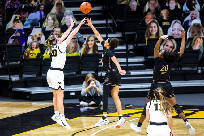Iowa guard Kate Martin, left, makes a 3-point basket as Northwestern guard Jordan Hamilton and Northwestern forward Paige Mott, right, defend during the first half of a NCAA Big Ten Conference women's basketball game, Thursday, Jan. 28, 2021, at Carver-Hawkeye Arena in Iowa City, Iowa.