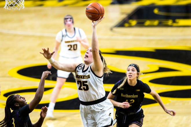 Iowa center Monika Czinano (25) makes a basket as Northwestern's Sydney Wood, left, and Northwestern forward Anna Morris, right, defend during the second half of a NCAA Big Ten Conference women's basketball game, Thursday, Jan. 28, 2021, at Carver-Hawkeye Arena in Iowa City, Iowa.