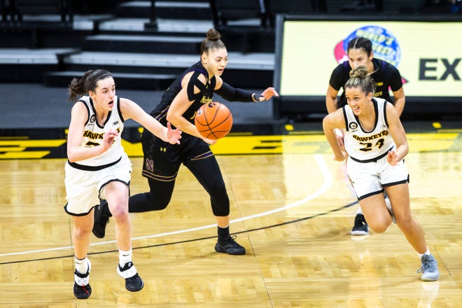 Iowa guard Caitlin Clark, left, gets a steal from Northwestern guard Lindsey Pulliam while on defense with teammate Gabbie Marshall (24) during the second half of a NCAA Big Ten Conference women's basketball game, Thursday, Jan. 28, 2021, at Carver-Hawkeye Arena in Iowa City, Iowa.