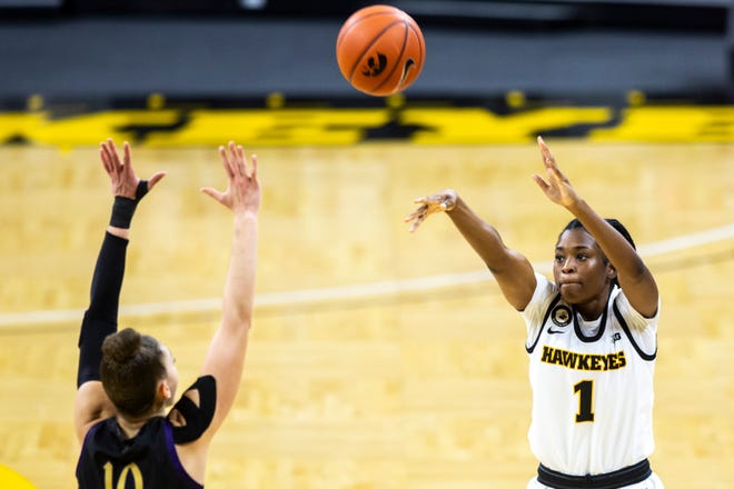 Iowa guard Tomi Taiwo (1) makes a 3-point basket as Northwestern guard Lindsey Pulliam (10) defends during the second half of a NCAA Big Ten Conference women's basketball game, Thursday, Jan. 28, 2021, at Carver-Hawkeye Arena in Iowa City, Iowa.