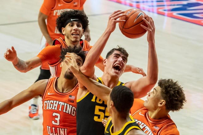 Jan 29, 2021; Champaign, Illinois, USA; Iowa Hawkeyes center Luka Garza (55) grabs a rebound against Illinois Fighting Illini guard Jacob Grandison (3) and forward Benjamin Bosmans-Verdonk (middle right) and guard Andre Curbelo (behind) during the first half at the State Farm Center.