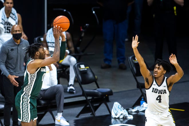 Michigan State forward Aaron Henry makes a 3-point basket as Iowa guard Ahron Ulis (4) defends during a NCAA Big Ten Conference men's basketball game, Tuesday, Feb. 2, 2021, at Carver-Hawkeye Arena in Iowa City, Iowa.