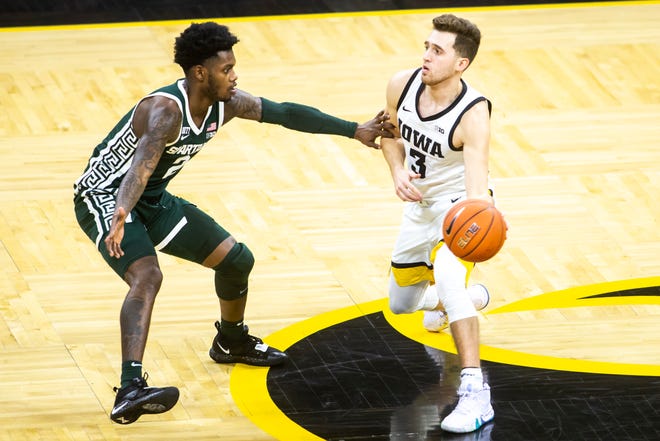 Iowa guard Jordan Bohannon (3) passes as Michigan State guard Rocket Watts (2) defends during a NCAA Big Ten Conference men's basketball game, Tuesday, Feb. 2, 2021, at Carver-Hawkeye Arena in Iowa City, Iowa.