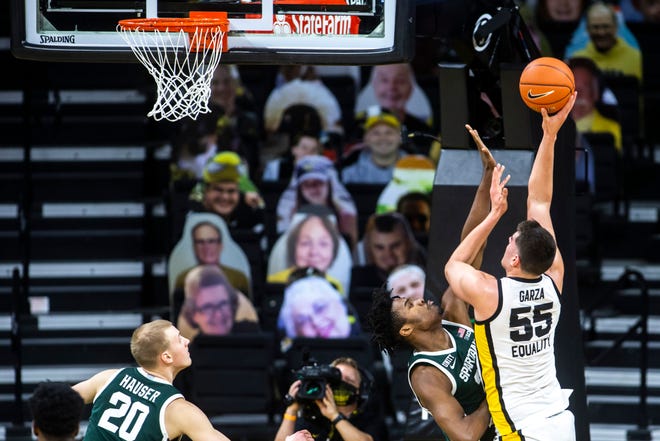 Iowa center Luka Garza (55) makes a basket as Michigan State forward Julius Marble II defends during a NCAA Big Ten Conference men's basketball game, Tuesday, Feb. 2, 2021, at Carver-Hawkeye Arena in Iowa City, Iowa.