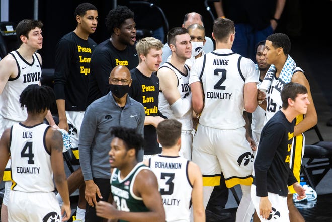 Iowa Hawkeyes teammates celebrate as Iowa forward Jack Nunge (2) heads to the bench in a timeout during a NCAA Big Ten Conference men's basketball game against Michigan State, Tuesday, Feb. 2, 2021, at Carver-Hawkeye Arena in Iowa City, Iowa.