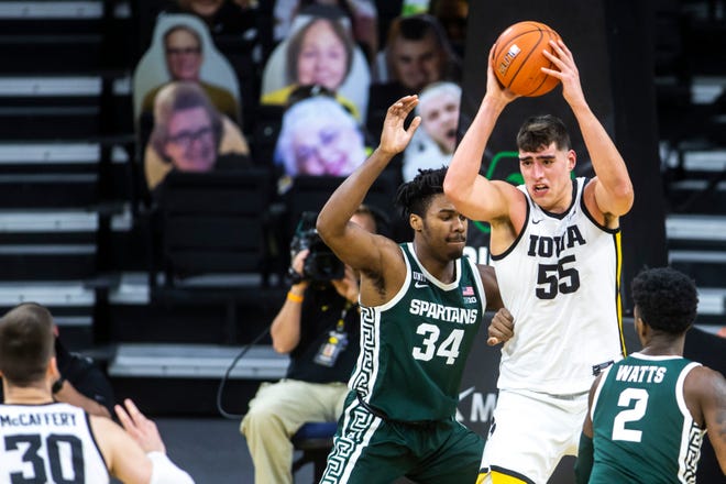 Iowa center Luka Garza (55) passes as Michigan State forward Julius Marble II (34) defends during a NCAA Big Ten Conference men's basketball game, Tuesday, Feb. 2, 2021, at Carver-Hawkeye Arena in Iowa City, Iowa.