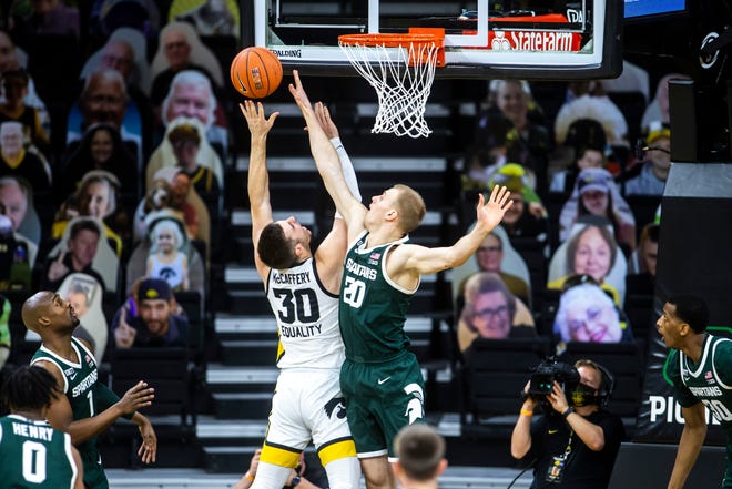 Iowa's Connor McCaffery (30) gets fouled by Michigan State forward Joey Hauser (20) during a NCAA Big Ten Conference men's basketball game, Tuesday, Feb. 2, 2021, at Carver-Hawkeye Arena in Iowa City, Iowa.