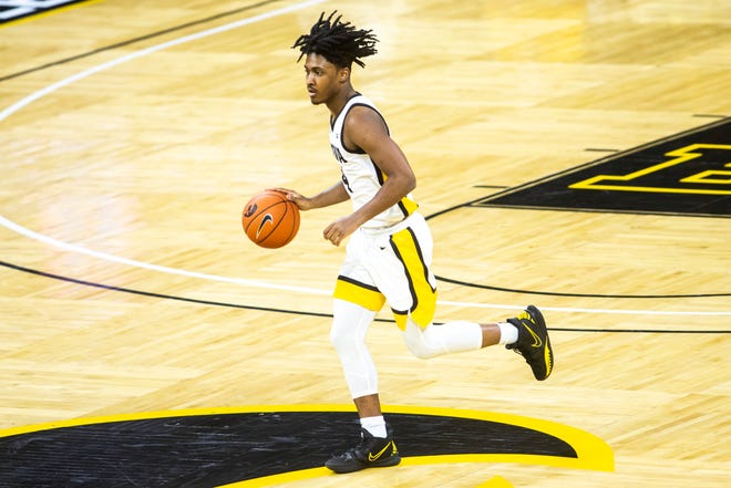 Iowa guard Ahron Ulis (4) takes the ball up court during a NCAA Big Ten Conference men's basketball game, Tuesday, Feb. 2, 2021, at Carver-Hawkeye Arena in Iowa City, Iowa.