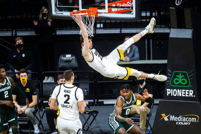 Iowa forward Patrick McCaffery (22) dunks the ball as Michigan State forward Aaron Henry (0) defends during a NCAA Big Ten Conference men's basketball game, Tuesday, Feb. 2, 2021, at Carver-Hawkeye Arena in Iowa City, Iowa.
