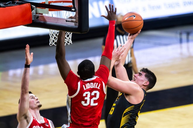 Iowa center Luka Garza (55) makes a basket as Ohio State forwards E.J. Liddell (32) and Kyle Young, left, during a NCAA Big Ten Conference men's basketball game, Thursday, Feb. 4, 2021, at Carver-Hawkeye Arena in Iowa City, Iowa.