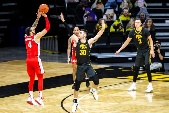 Ohio State guard Duane Washington Jr. (4) makes a 3-point basket as Iowa's Connor McCaffery (30) defends in the second half during a NCAA Big Ten Conference men's basketball game, Thursday, Feb. 4, 2021, at Carver-Hawkeye Arena in Iowa City, Iowa.