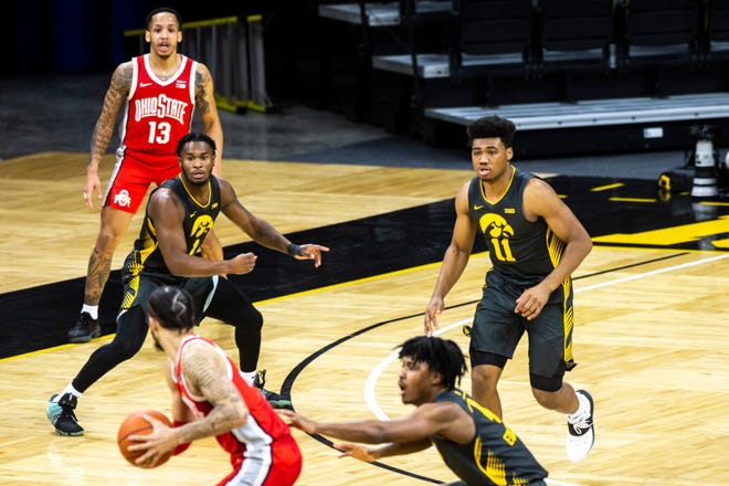 Iowa guards Joe Toussaint (1) and Tony Perkins (11) defend as teammate Ahron Ulis, foreground right, covers Ohio State guard Duane Washington Jr. during a NCAA Big Ten Conference men's basketball game, Thursday, Feb. 4, 2021, at Carver-Hawkeye Arena in Iowa City, Iowa.